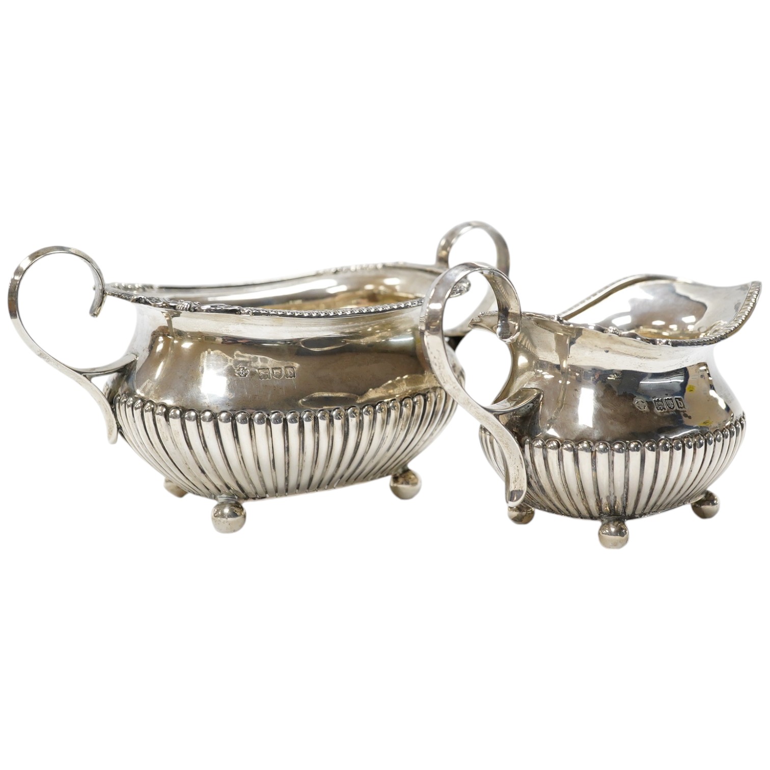 A late Victorian demi-fluted silver sugar bowl and a matching milk jug, by William Hutton & Sons, London, 1897, 12.6oz. Condition - good